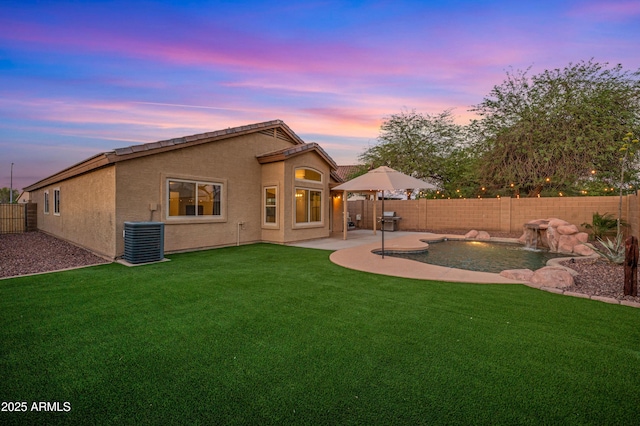 6309 W Hughes Dr, Phoenix, AZ 85043 - back of house featuring cooling unit, a patio area, and stucco siding