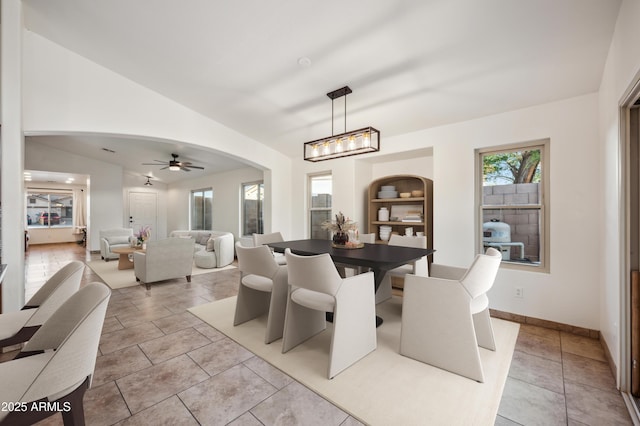 6309 W Hughes Dr, Phoenix, AZ 85043 - dining space with a ceiling fan, arched walkways, a chandelier, baseboards, and vaulted ceiling