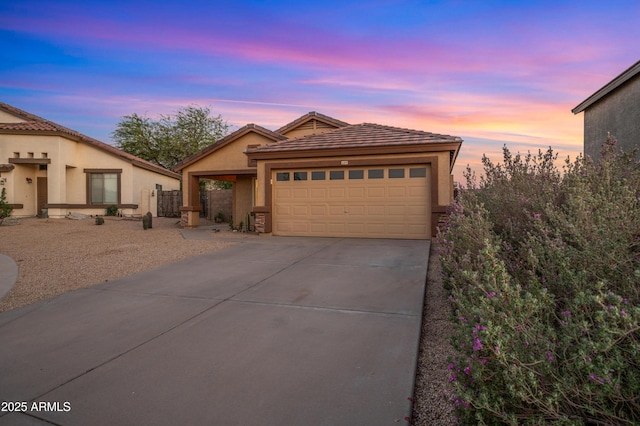 6309 W Hughes Dr, Phoenix, AZ 85043 - view of front facade with an attached garage, driveway, stucco siding, and a tiled roof