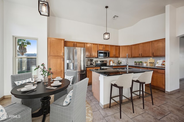 6309 W Hughes Dr, Phoenix, AZ 85043 - kitchen with stainless steel appliances, a high ceiling, a sink, dark countertops, and tasteful backsplash
