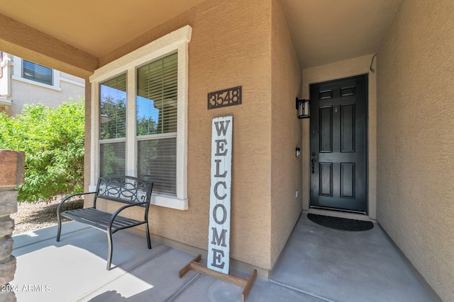 view of exterior entry featuring covered porch