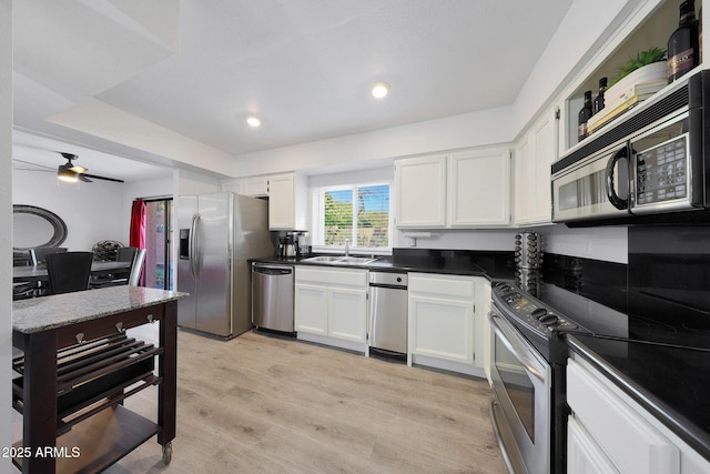 kitchen with white cabinetry, sink, ceiling fan, light hardwood / wood-style floors, and stainless steel appliances