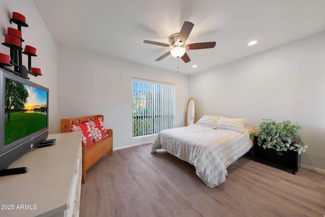 bedroom with light hardwood / wood-style floors and ceiling fan