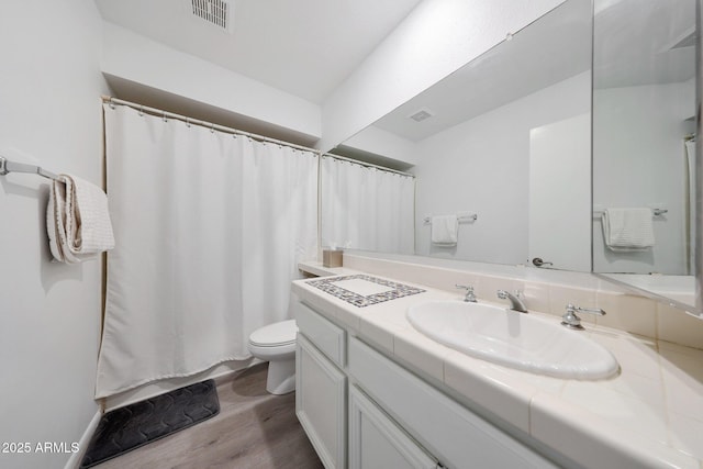 bathroom featuring wood-type flooring, toilet, and vanity