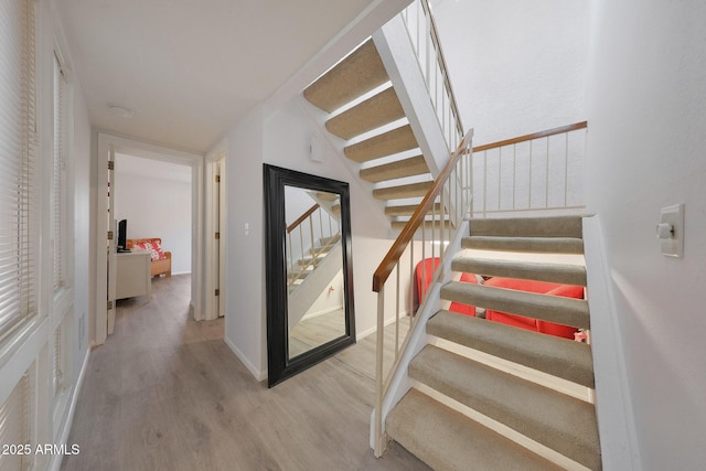 stairs featuring hardwood / wood-style floors