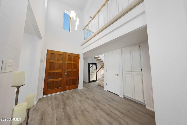 foyer featuring a towering ceiling and light hardwood / wood-style flooring