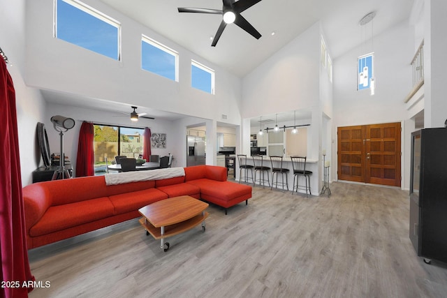 living room with ceiling fan and light hardwood / wood-style flooring