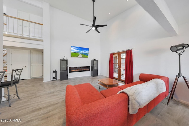 living room with french doors, ceiling fan, a high ceiling, and hardwood / wood-style flooring