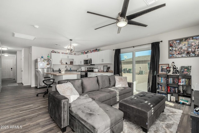 living room with ceiling fan, dark wood-type flooring, and sink