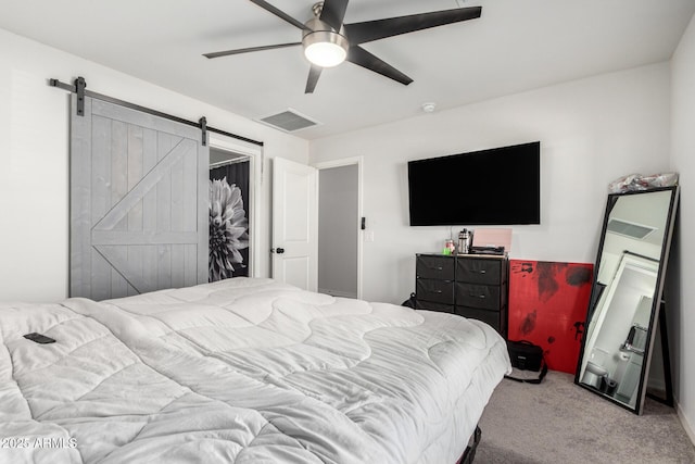 carpeted bedroom featuring ceiling fan, a barn door, and a closet