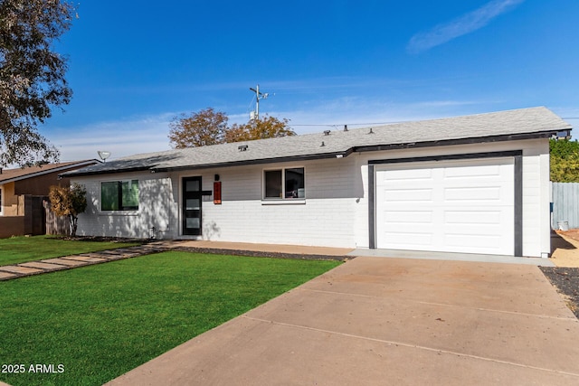 ranch-style home with a shingled roof, concrete driveway, an attached garage, a front lawn, and brick siding