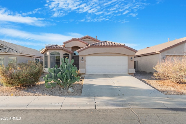 mediterranean / spanish house featuring stucco siding, a garage, concrete driveway, and a tiled roof