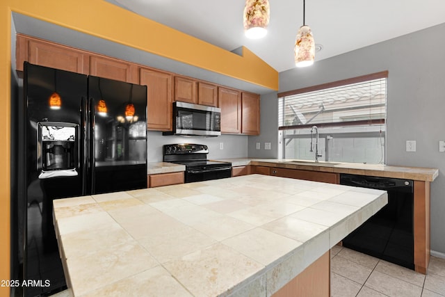 kitchen featuring light tile patterned floors, brown cabinetry, a sink, black appliances, and pendant lighting