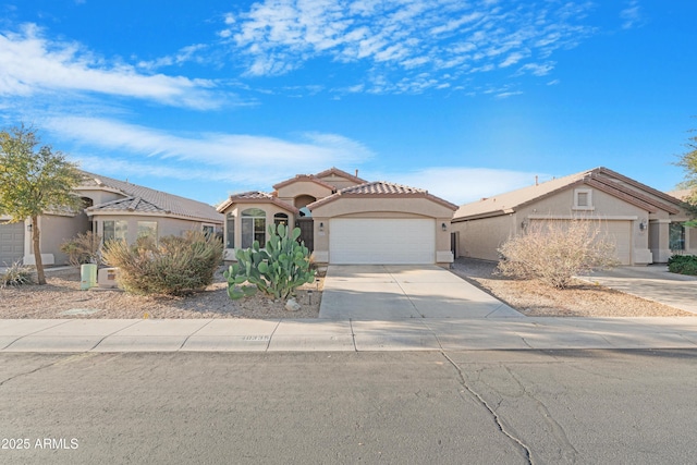 mediterranean / spanish home featuring a tile roof, a garage, driveway, and stucco siding