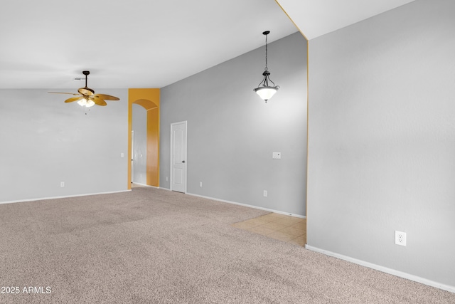 empty room featuring baseboards, lofted ceiling, carpet, and a ceiling fan