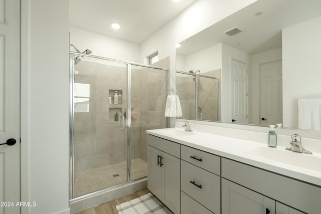 bathroom featuring hardwood / wood-style floors, vanity, and walk in shower