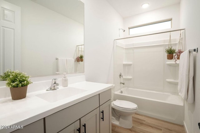 full bathroom featuring toilet, vanity,  shower combination, and hardwood / wood-style flooring