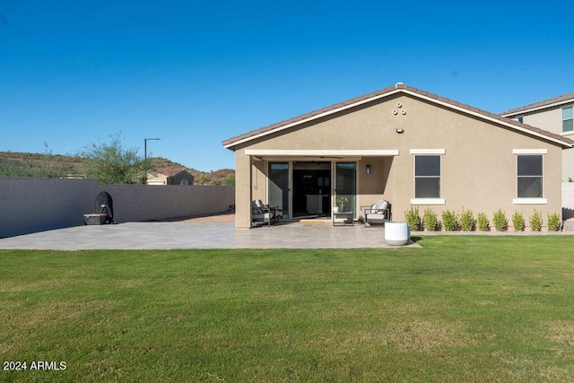 back of property featuring a patio area and a yard