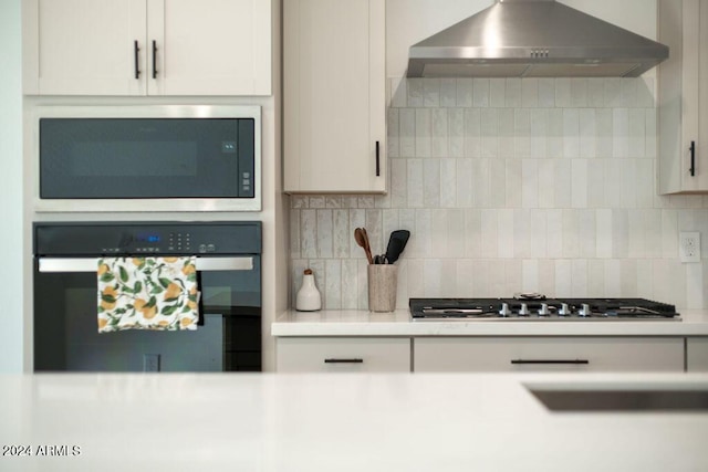 kitchen featuring wall oven, backsplash, stainless steel gas cooktop, built in microwave, and wall chimney range hood