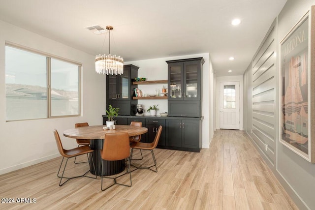 dining area featuring light wood-type flooring and an inviting chandelier