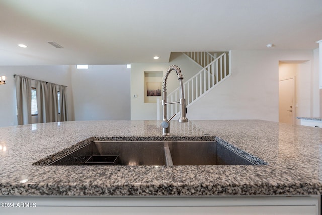 kitchen featuring dark stone counters and sink