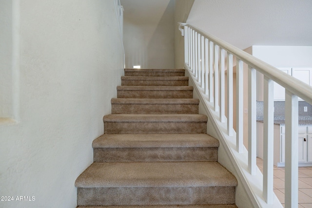 staircase featuring tile patterned flooring