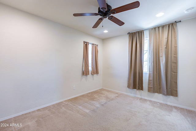 empty room featuring ceiling fan and light carpet