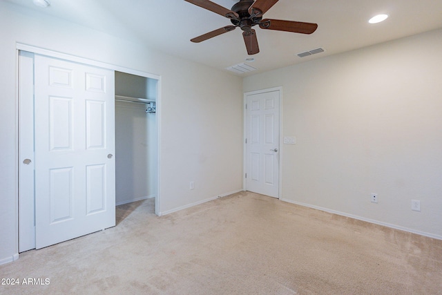 unfurnished bedroom with a closet, light carpet, and ceiling fan