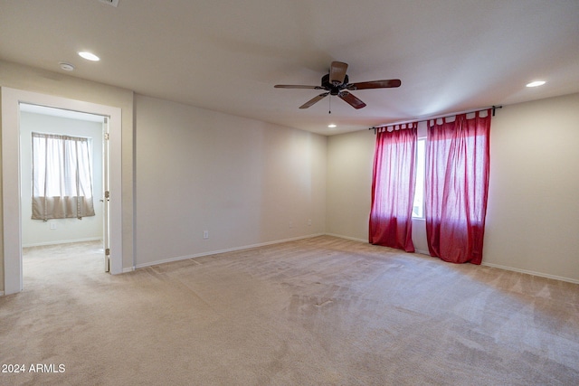 empty room featuring ceiling fan and light colored carpet