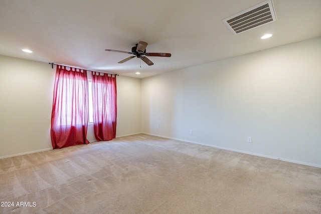 empty room featuring ceiling fan and light carpet