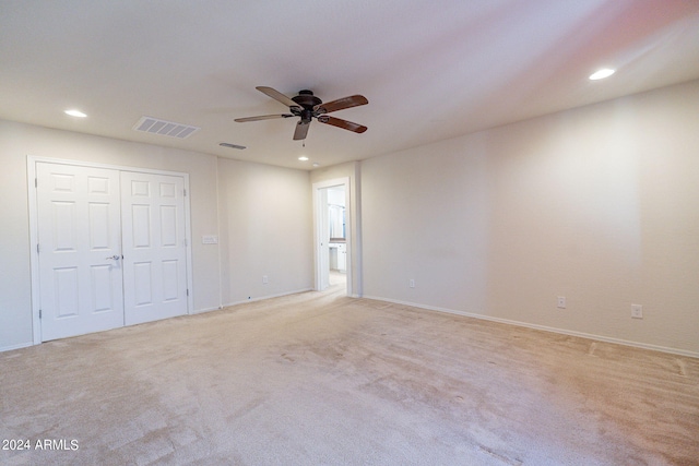 unfurnished bedroom with ceiling fan and light colored carpet