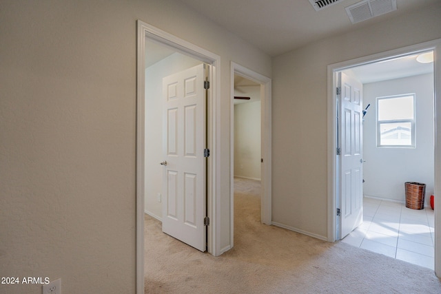 hall with light colored carpet