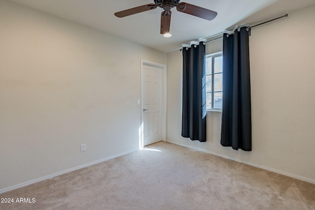 unfurnished room featuring light carpet and ceiling fan