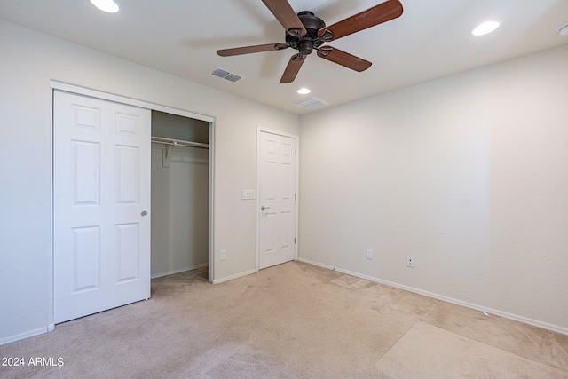 unfurnished bedroom featuring ceiling fan, a closet, and light colored carpet