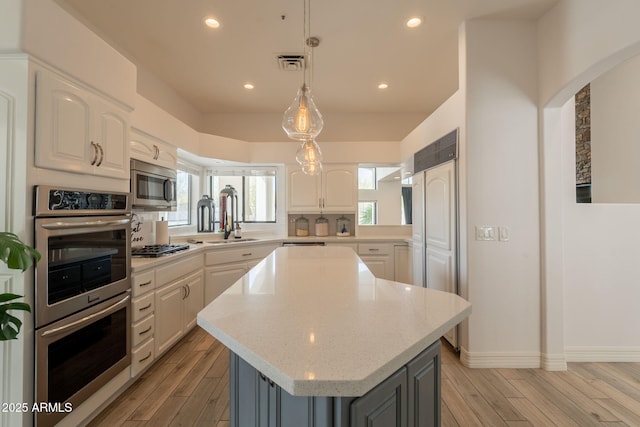 8502 E Santa Catalina Dr, Scottsdale, AZ 85255 - kitchen with stainless steel appliances, a sink, light wood-type flooring, white cabinets, and recessed lighting
