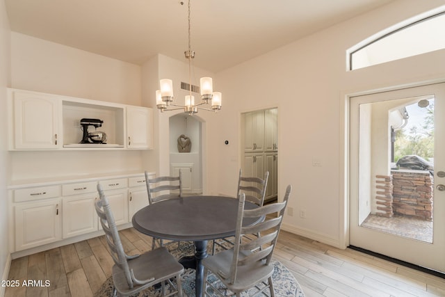 8502 E Santa Catalina Dr, Scottsdale, AZ 85255 - dining space featuring light wood-style floors, a chandelier, baseboards, and high vaulted ceiling