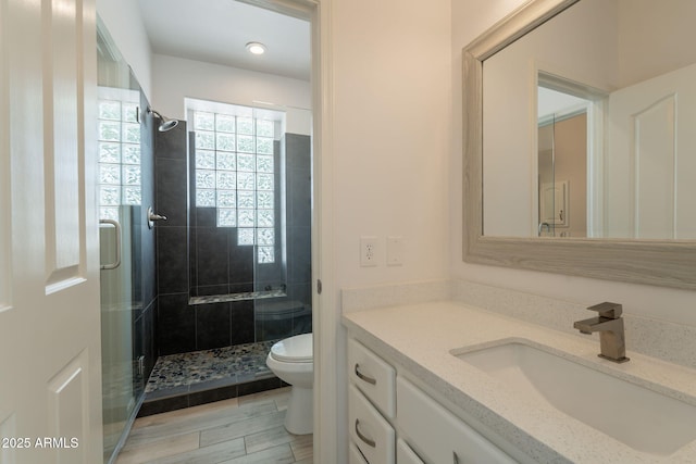 8502 E Santa Catalina Dr, Scottsdale, AZ 85255 - bathroom with toilet, a stall shower, vanity, and wood finished floors