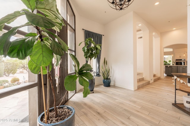 8502 E Santa Catalina Dr, Scottsdale, AZ 85255 - hallway featuring arched walkways, wood finished floors, baseboards, a chandelier, and recessed lighting