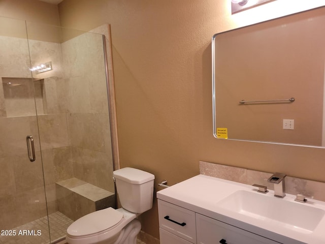 bathroom with vanity, toilet, and a shower with shower door