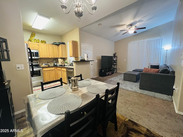 dining space featuring ceiling fan with notable chandelier, vaulted ceiling, and carpet