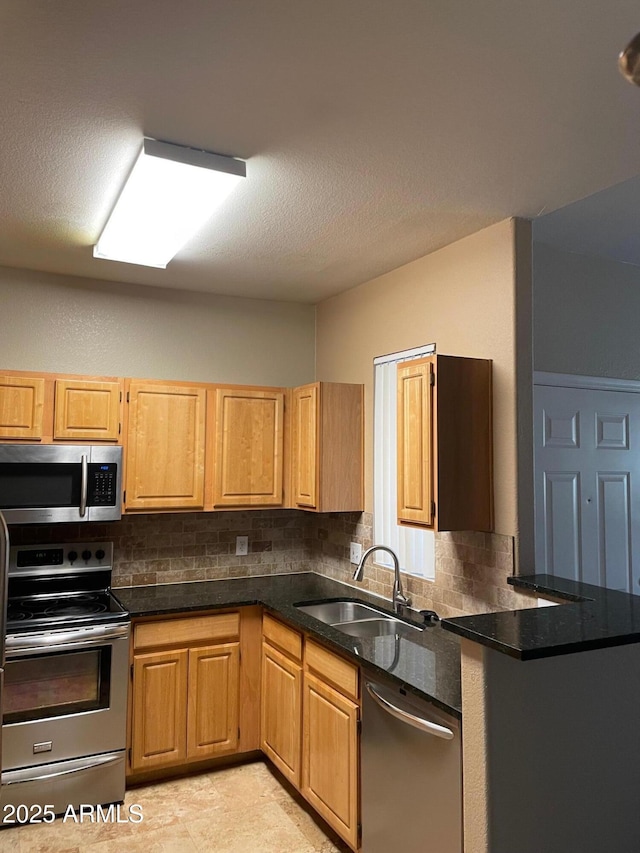 kitchen featuring appliances with stainless steel finishes, sink, a textured ceiling, and backsplash