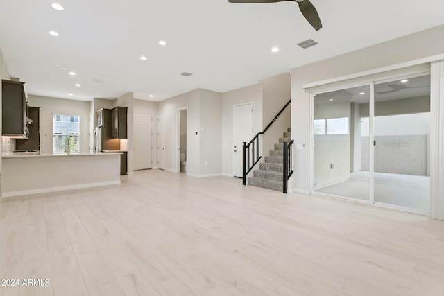 unfurnished living room featuring ceiling fan and light hardwood / wood-style flooring