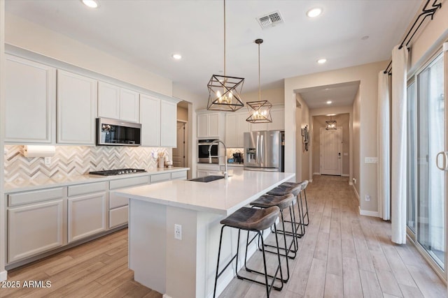1895 N 141st Ave, Goodyear, AZ 85395 - kitchen featuring stainless steel appliances, a sink, backsplash, a center island with sink, and recessed lighting