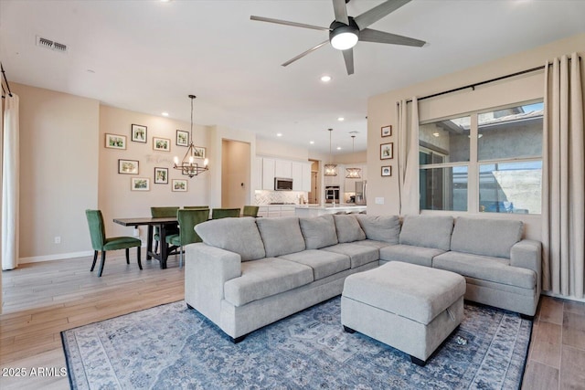 1895 N 141st Ave, Goodyear, AZ 85395 - living area with a chandelier, light wood-style flooring, ceiling fan, recessed lighting, and baseboards