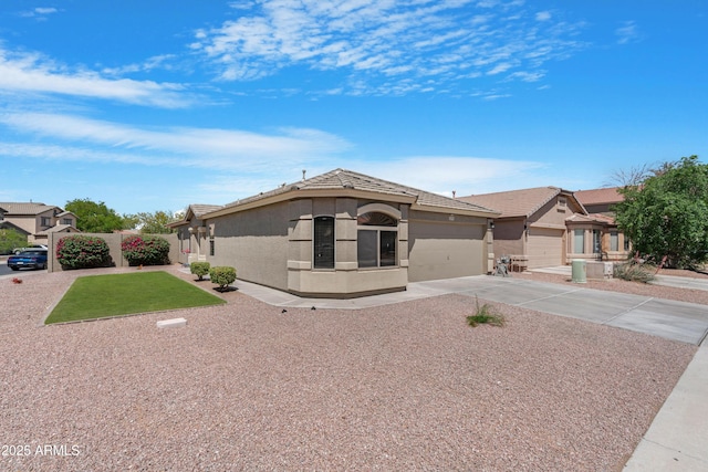 ranch-style home with concrete driveway, an attached garage, a front lawn, and stucco siding