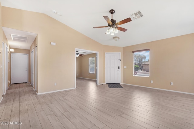 unfurnished living room with a healthy amount of sunlight, ceiling fan, vaulted ceiling, and visible vents