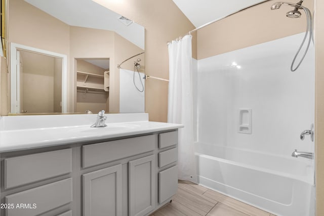 bathroom featuring visible vents, shower / bathtub combination with curtain, and vanity