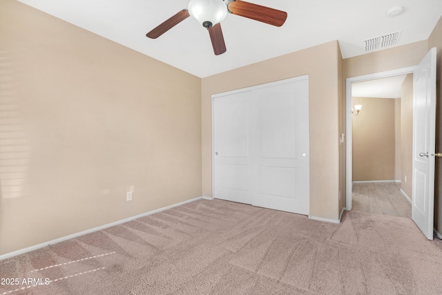 unfurnished bedroom with ceiling fan, visible vents, baseboards, a closet, and carpet