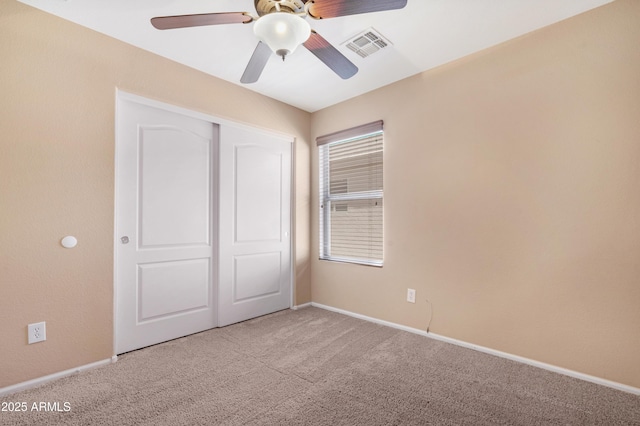 unfurnished bedroom featuring visible vents, baseboards, carpet floors, and a closet
