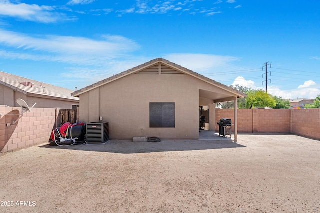 back of house with central air condition unit, a fenced backyard, a patio area, and stucco siding